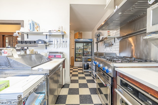 kitchen featuring extractor fan, stainless steel appliances, and backsplash