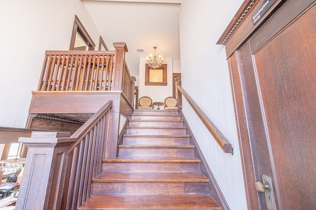 staircase featuring a notable chandelier and hardwood / wood-style flooring