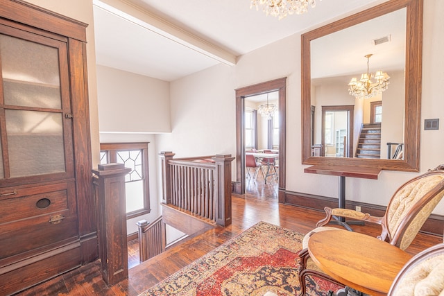 corridor featuring beamed ceiling, an inviting chandelier, and dark hardwood / wood-style floors