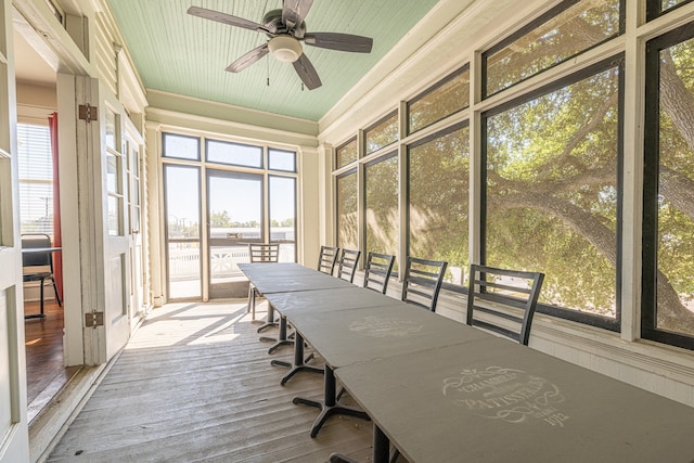 unfurnished sunroom featuring ceiling fan and a wealth of natural light