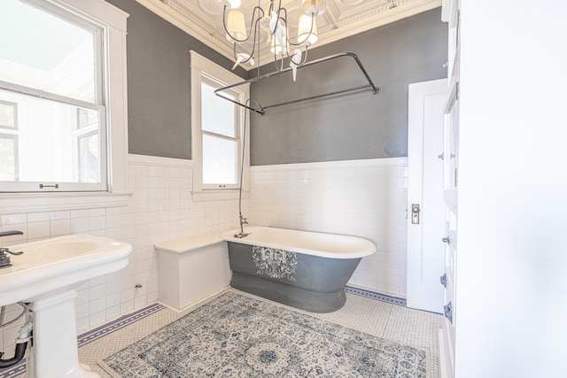 bathroom featuring tile walls, ornamental molding, a tub, and tile patterned flooring