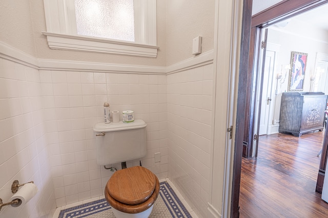 bathroom with tile walls, hardwood / wood-style flooring, and toilet