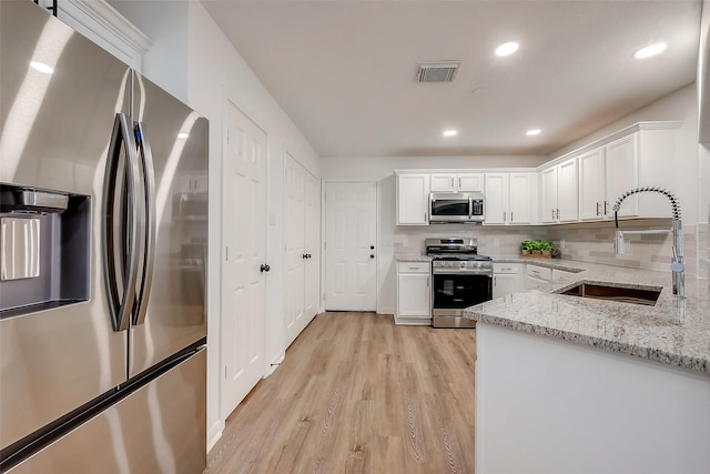 kitchen featuring light stone countertops, sink, white cabinetry, and stainless steel appliances