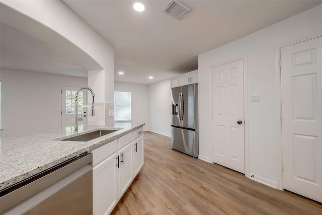 kitchen featuring light stone counters, sink, white cabinets, and appliances with stainless steel finishes