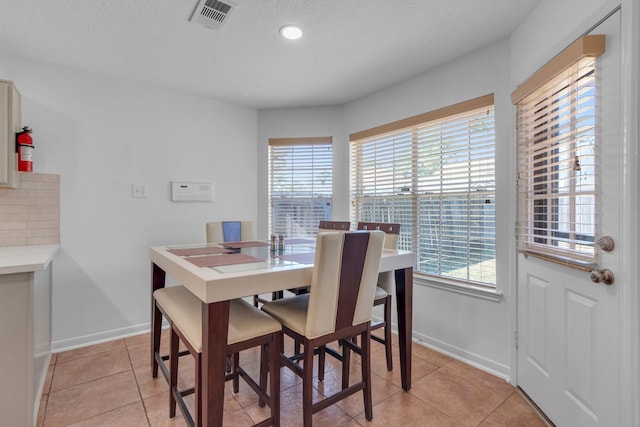 dining room featuring light tile patterned floors and a textured ceiling