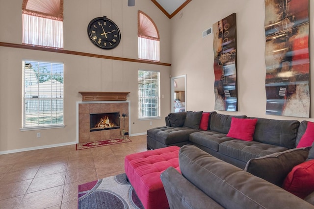 living room with light tile patterned floors, high vaulted ceiling, plenty of natural light, and a tiled fireplace