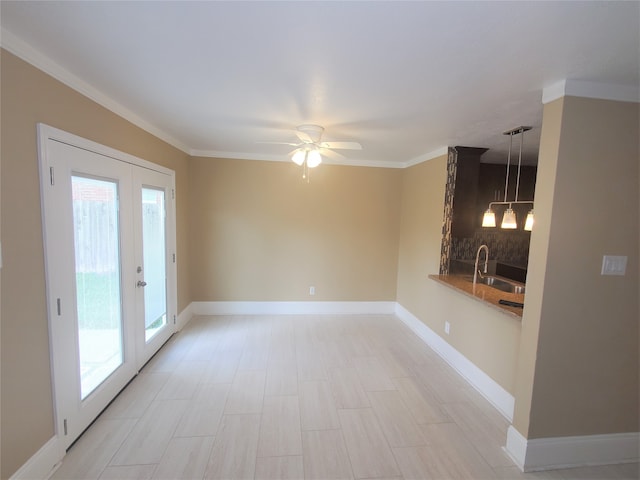 empty room featuring crown molding, french doors, sink, and ceiling fan