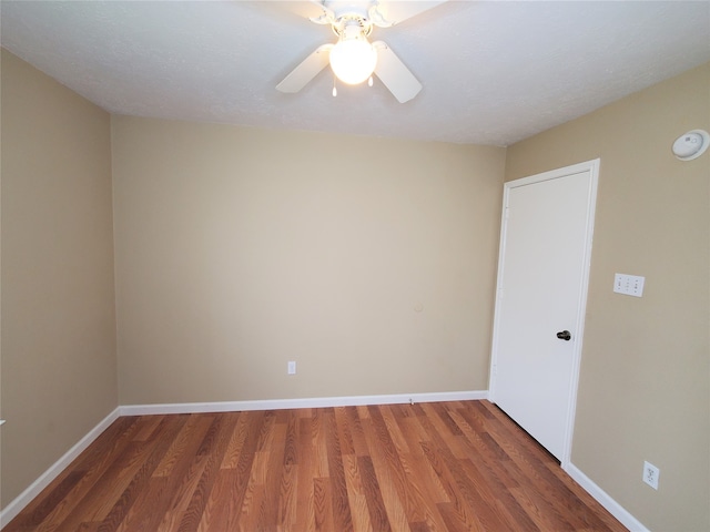 spare room featuring dark wood-type flooring, a textured ceiling, and ceiling fan