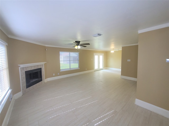 unfurnished living room featuring ceiling fan, crown molding, and a fireplace