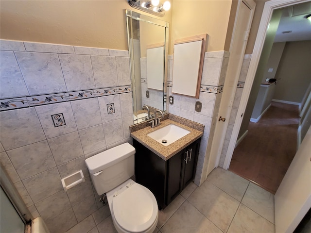 bathroom featuring vanity, toilet, tile walls, and tile patterned flooring