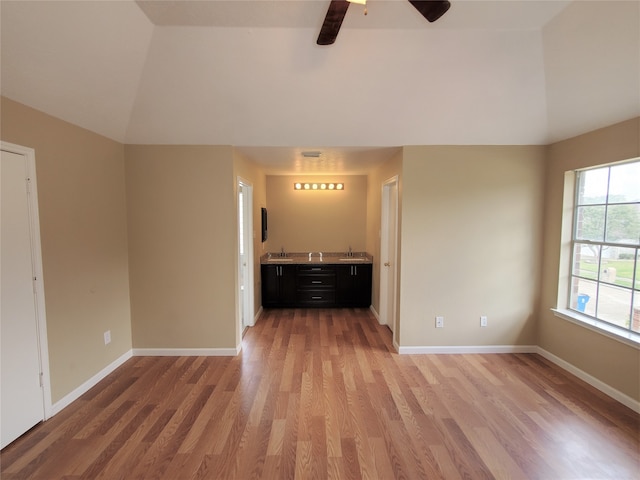 unfurnished living room featuring lofted ceiling, hardwood / wood-style flooring, and ceiling fan