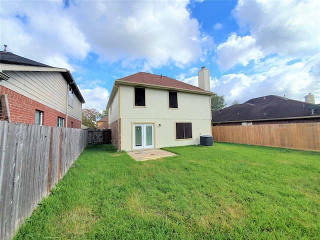 back of house featuring a yard, central AC, and french doors