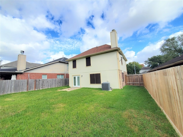 rear view of house with a yard and cooling unit