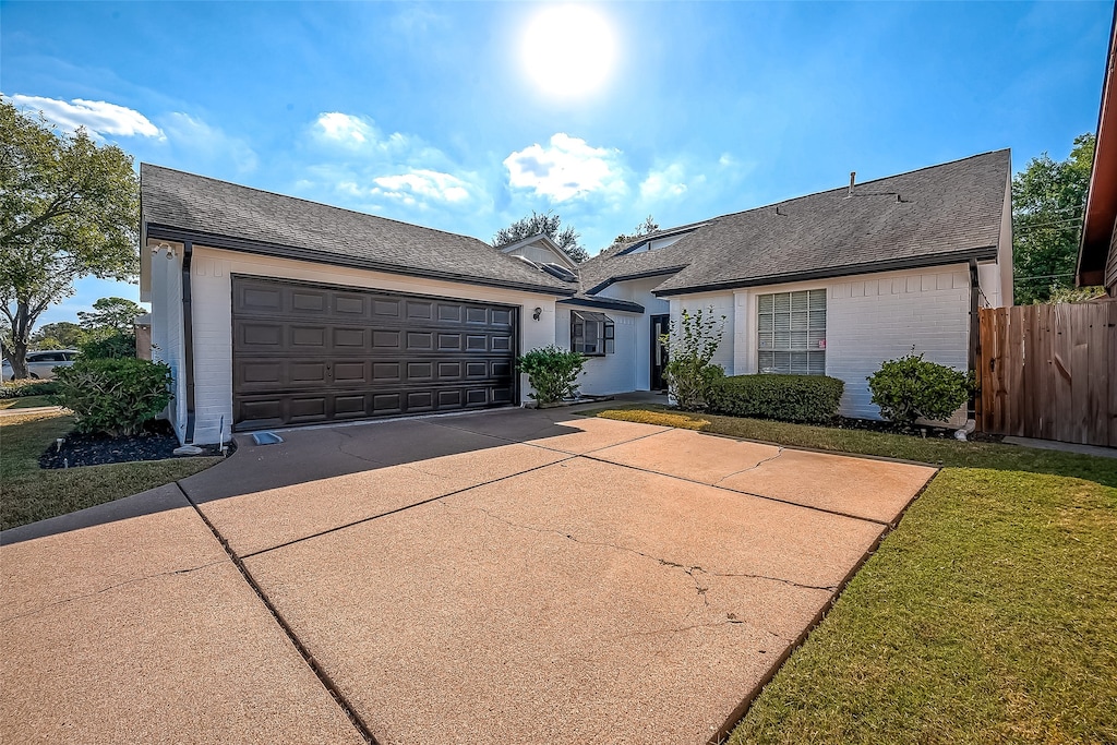 ranch-style home with a front yard and a garage