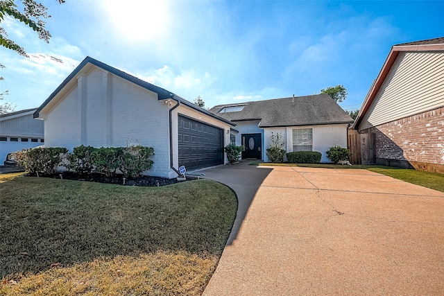 ranch-style house featuring a garage and a front lawn