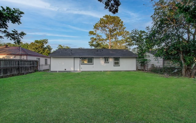 rear view of property featuring a yard