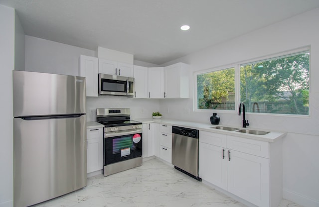 kitchen with sink, appliances with stainless steel finishes, and white cabinetry