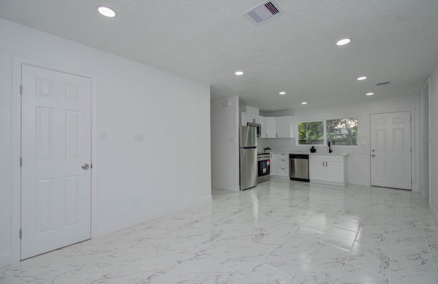 unfurnished living room with a textured ceiling and sink