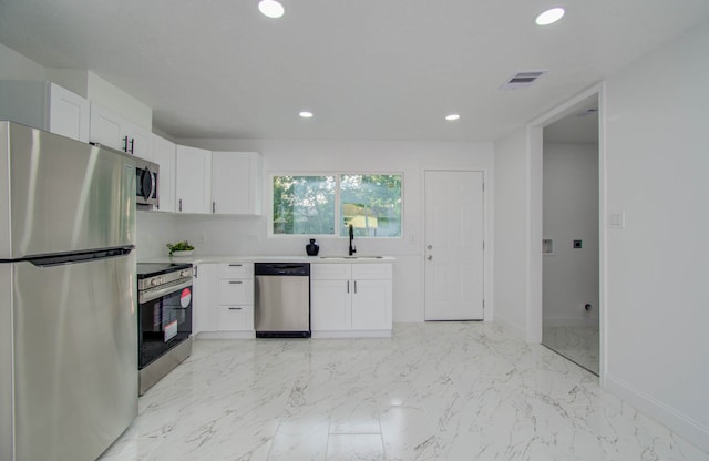 kitchen with sink, white cabinets, decorative backsplash, and stainless steel appliances