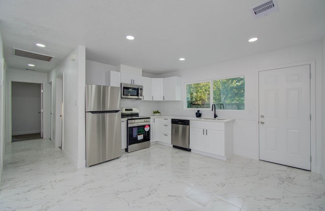 kitchen featuring white cabinetry, stainless steel appliances, and sink