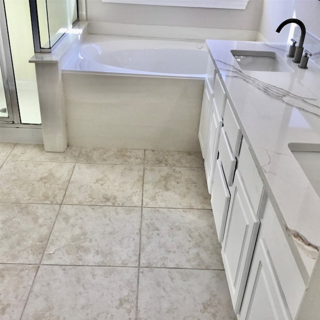 bathroom featuring vanity, a tub, and tile patterned floors