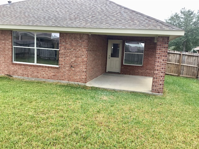 rear view of property featuring a patio area and a lawn