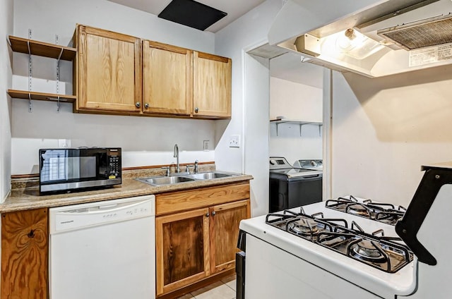 kitchen featuring white appliances, ventilation hood, sink, washing machine and dryer, and light tile patterned floors