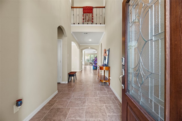 entryway featuring crown molding and a high ceiling