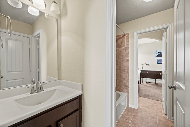 bathroom with vanity, shower / washtub combination, a textured ceiling, and tile patterned flooring