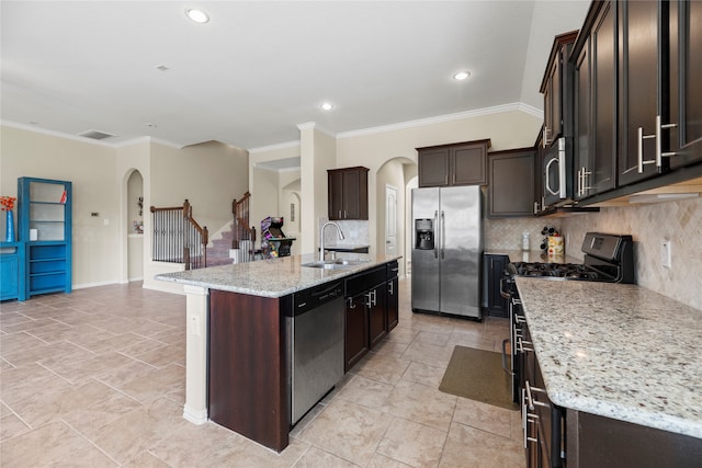 kitchen featuring decorative backsplash, an island with sink, stainless steel appliances, crown molding, and sink