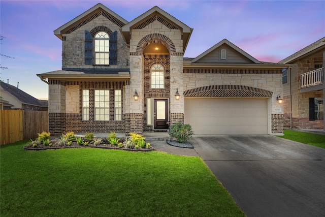 view of front facade with a balcony, a garage, and a lawn