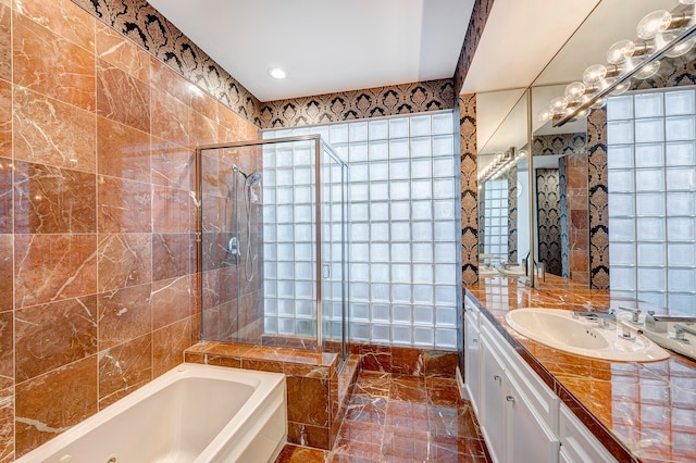 bathroom featuring vanity, independent shower and bath, and tile walls