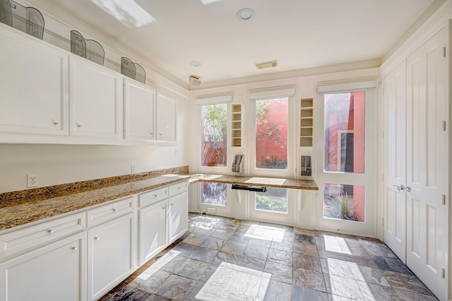 kitchen with stone countertops and white cabinets