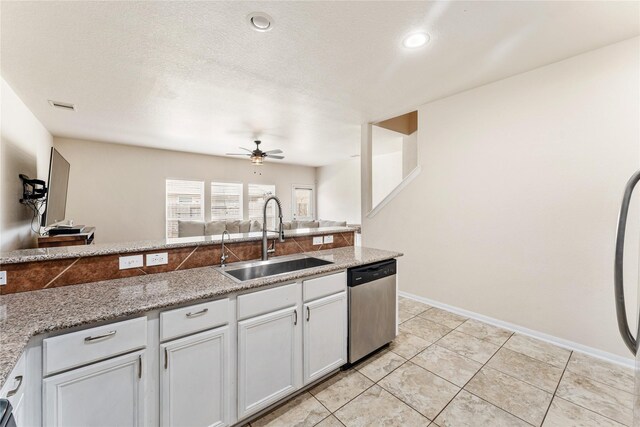 kitchen with white cabinetry, stainless steel dishwasher, sink, and light stone counters