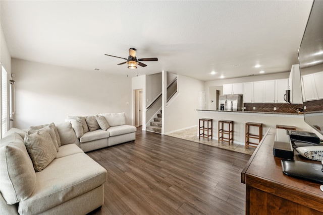 living area with baseboards, ceiling fan, stairs, recessed lighting, and dark wood-style floors