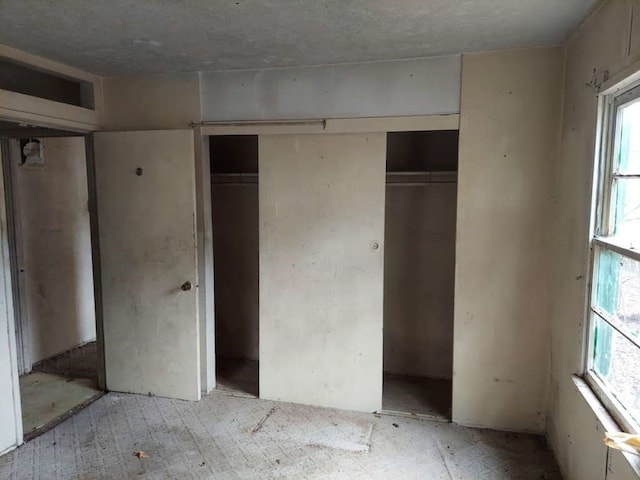 unfurnished bedroom with multiple windows and a closet