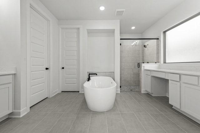 bathroom with tile patterned floors, vanity, and separate shower and tub