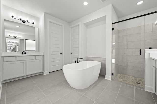 bathroom with tile patterned floors, vanity, tile walls, and plus walk in shower