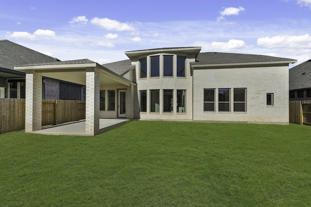 back of property featuring a yard and a patio