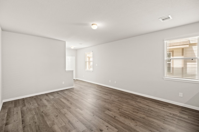 unfurnished room with dark wood-type flooring