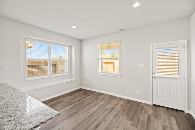 unfurnished dining area featuring a healthy amount of sunlight and wood-type flooring