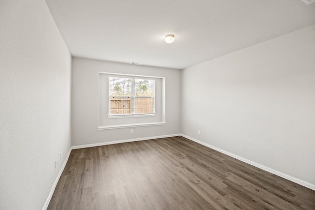 unfurnished room with dark hardwood / wood-style flooring