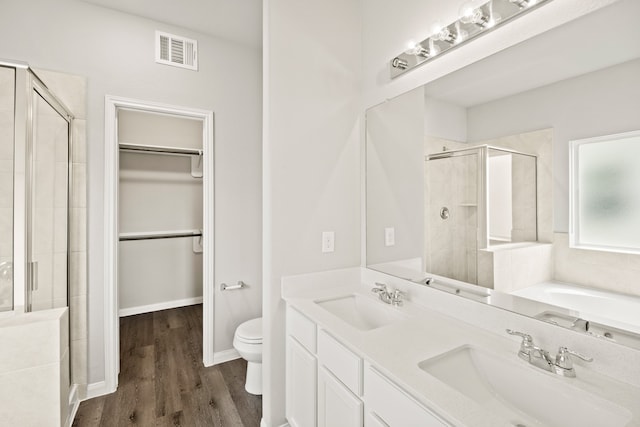 full bathroom with vanity, toilet, hardwood / wood-style flooring, and plus walk in shower