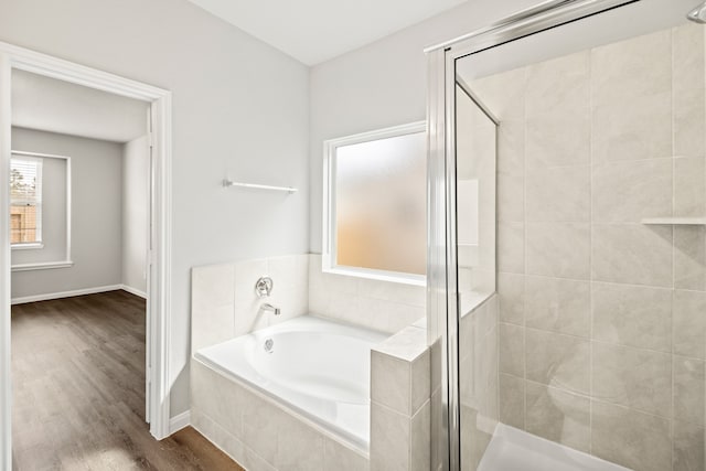 bathroom with hardwood / wood-style flooring and independent shower and bath