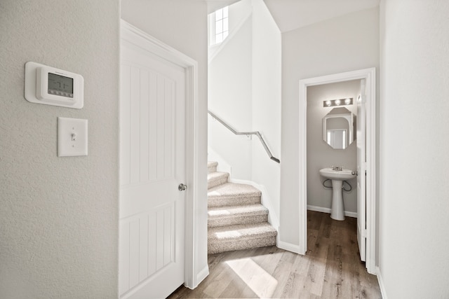 staircase with hardwood / wood-style floors and sink