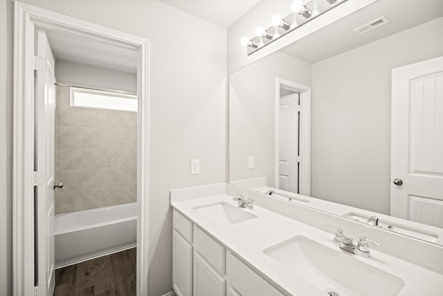 bathroom featuring vanity, tiled shower / bath, and wood-type flooring