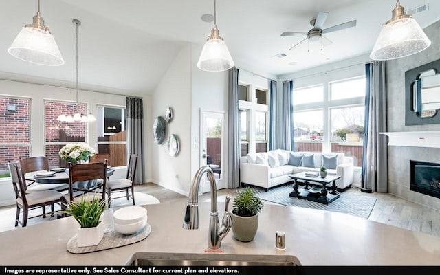 living area featuring visible vents, a ceiling fan, wood finished floors, and a tile fireplace