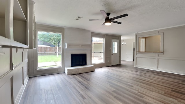 unfurnished living room with ceiling fan, a wealth of natural light, and hardwood / wood-style floors