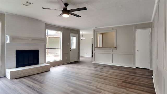 unfurnished living room with a textured ceiling, a fireplace, hardwood / wood-style flooring, and ceiling fan