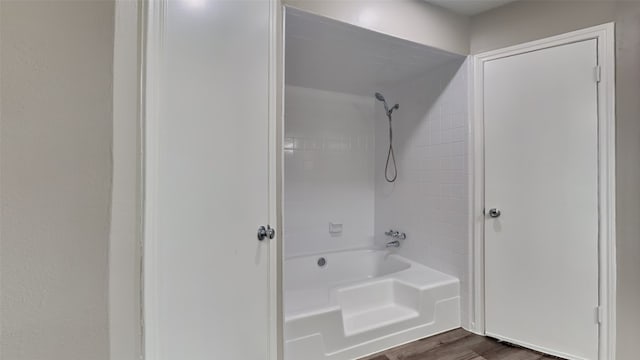 bathroom with tiled shower / bath combo and hardwood / wood-style floors